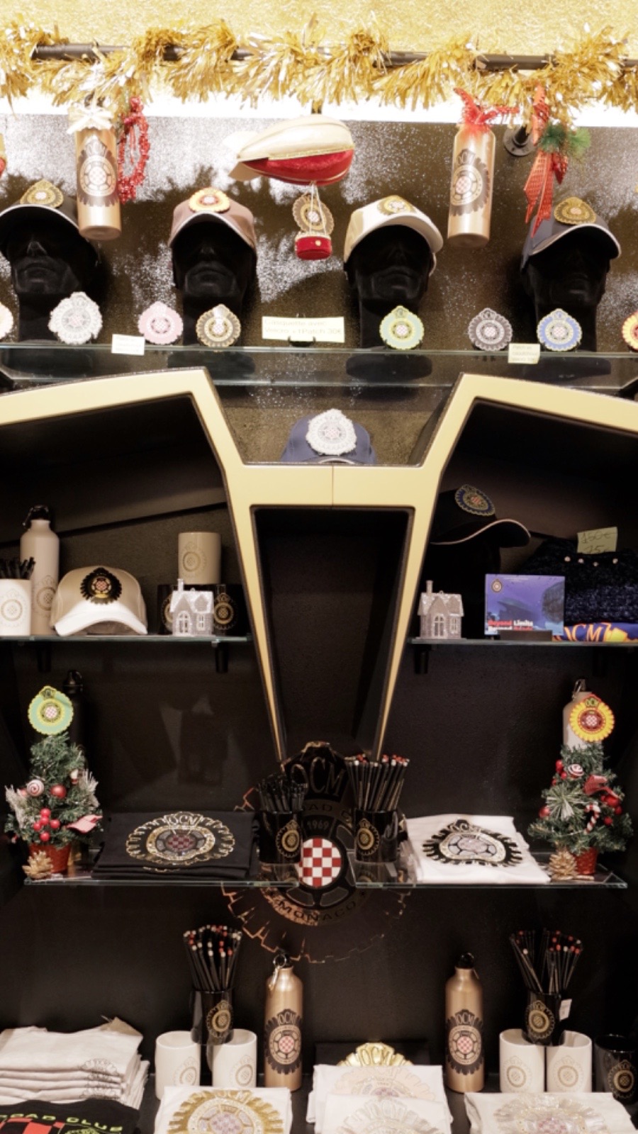 Parete prodotti Offroad Club Monaco con cappellini, t-shirt e accessori