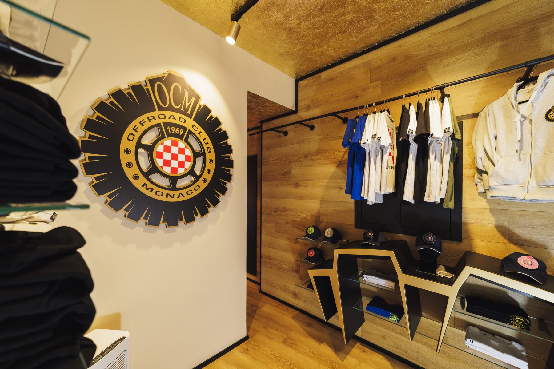 Il logo Offroad Club Monaco a parete e la collezione appesa nello Store