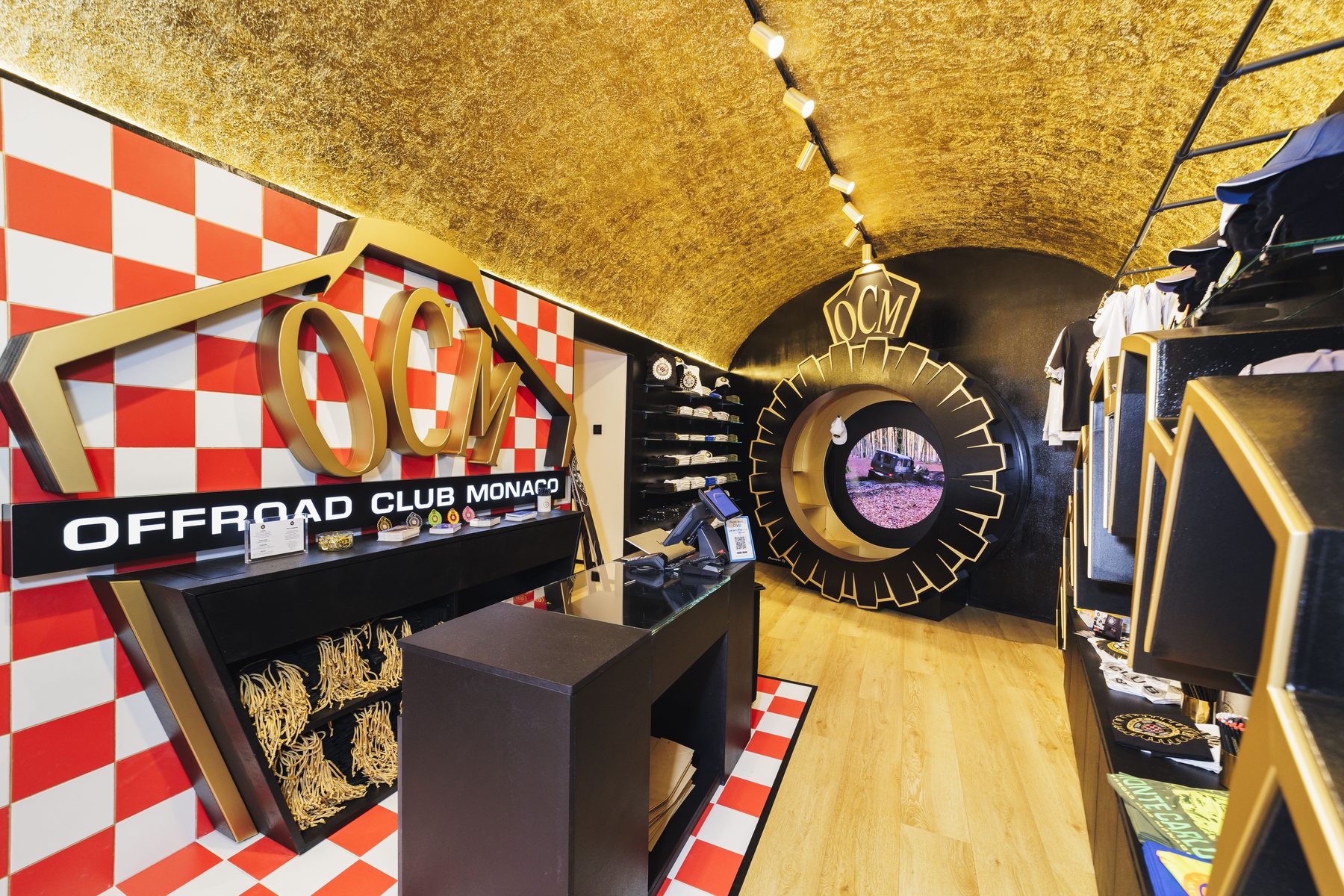 Interno dello Store con soffitto a foglia d'oro, parete a scacchi e grande logo OCM