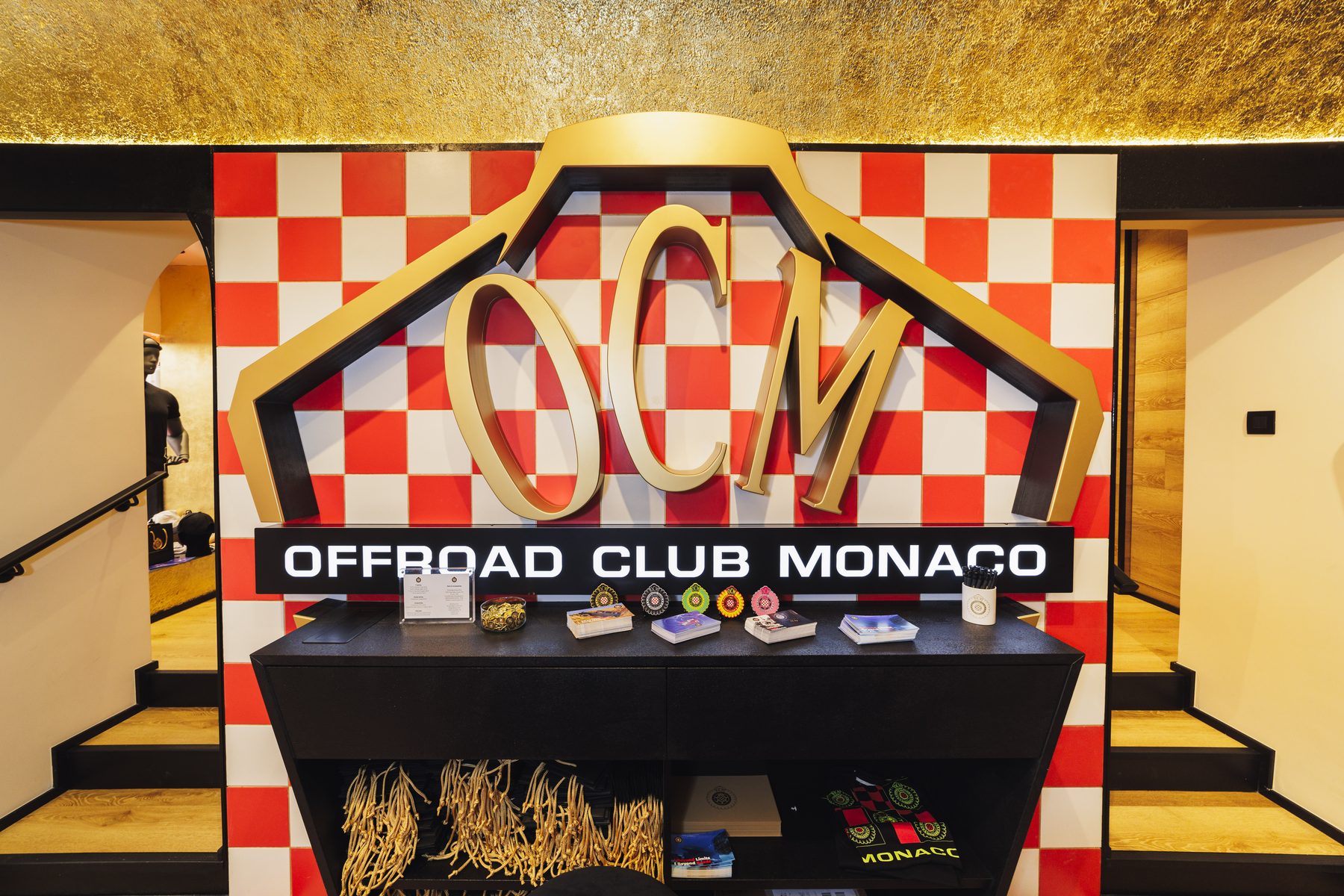 La parete a scacchi con il logo Offroad Club Monaco e il banco espositivo