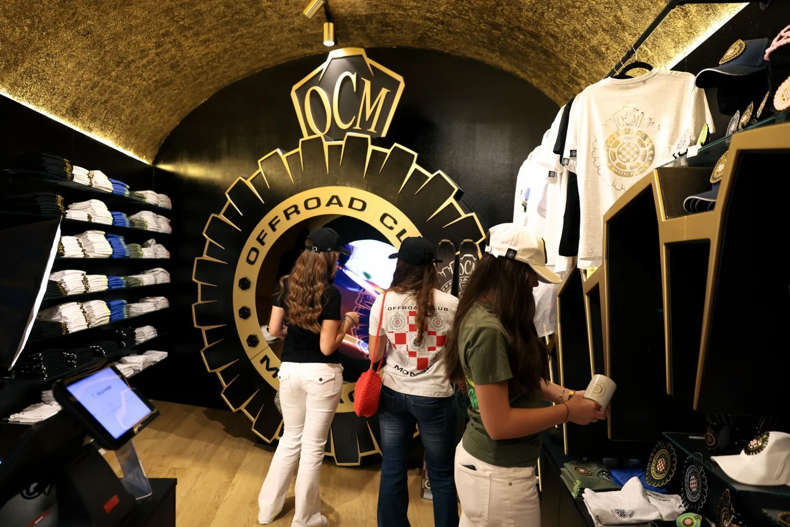 Visitatrici davanti al grande logo Offroad Club Monaco all'interno dello Store